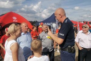 policjant pokazuje obecnym urządzenie do badania trzeźwości