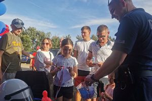 policjant częstuje dzieci słodyczami