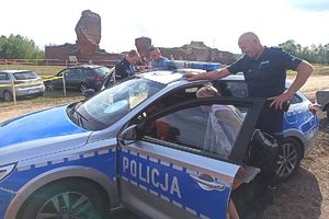 policjanci z dziećmi przy radiowozie