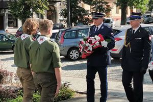 komendant Policji i komendant Straży Pożarnej przekazują kwiaty harcerzom
