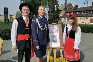 oficer prasowy komendy i para uczestników Narodowego Czytania w strojach ludowych