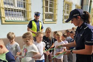 policjanci rozdają dzieciom opaski odblaskowe