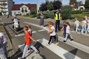 dzieci z policjantami przechodzą przez jezdnię