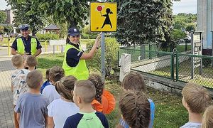 policjantka pokazuje dzieciom znak