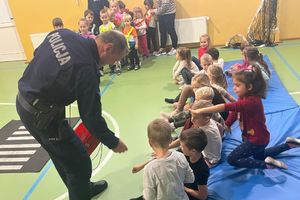 policjant rozdaje dzieciom opaski odblaskowe