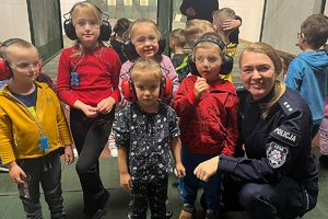 policjantka z dziećmi w okularach i słuchawkach ochronnych