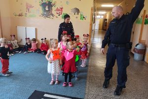 policjanci instruują dzieci jak przechodzić przez pasy