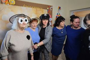 seniorzy pozują przy fotobudce