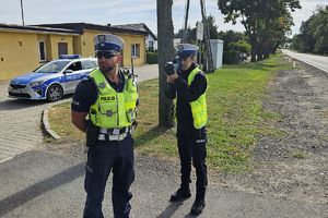 patrol policjantów - policjantka mierzy prędkość pojazdu