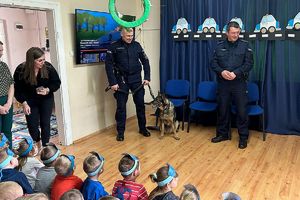 policjanci z psem rozmawiają z dziećmi