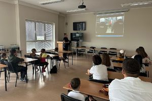 funkcjonariusza wyświetla dzieciom film o zawodzie policjanta