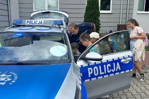 policjant pokazuje dzieciom radiowóz