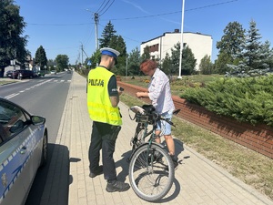 Policjant kontroluje rowerzystę