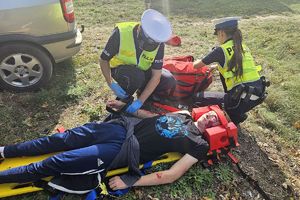 policjanci opatrują mężczyznę leżącego na desce ratowniczej