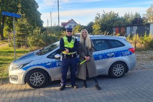 policjant wręcza odblask kobiecie