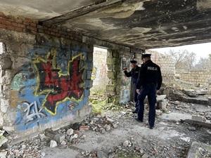 Policjanci chodzą po pustostanie