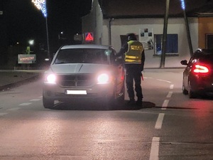 Policjant stoi przy pojeździe i sprawdza trzeźwość kierującego