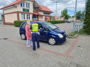 Policjant rozmawia przy samochodzie
