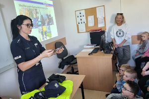policjantka pokazuje dzieciom kajdanki