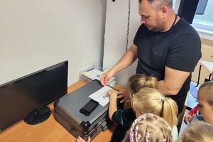technik pomaga dziecku odwzorować swoją odbitkę palca