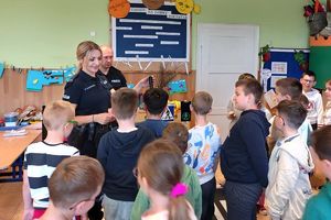 policjanci pokazują dzieciom wyposażenie do służby