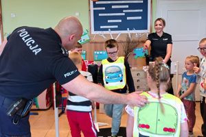 policjanci uczą dzieci prawidłowego przechodzenia przez jezdnię