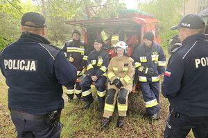 policjanci rozmawiają ze strażakami ochotnikami