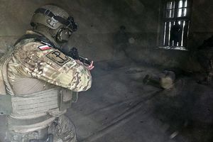 policjant z samodzielnego pododdziału kontrterrorystyczego celuje do terrorysty