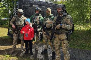 policjanci z samodzielnego pododdziału kontrterrorystyczego pozują z młodym ratownikiem