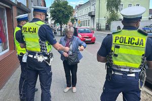 policjanci wręczją kobiecie ulotkę akcji &quot;Odłóż telefon i żyj&quot;