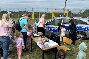 policyjne stoisko, policjantka pokazuje dzieciom radiowów