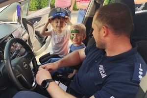 policjant pokazuje dzieciom radiowóz