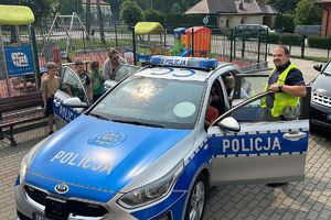 policjant pokazuje dzieciom radiowóz