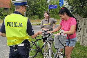 policjant wręcza odblask rowerzystkom
