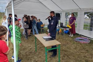 policjant podczas pikniku w Chrostkowie przekazuje dzieciom informacje profilaktyczne