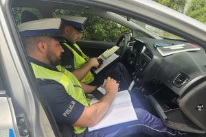 policjanci w radiowozie sprawdzają dokumenty