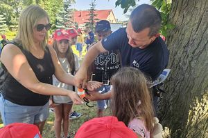 policjant pokazuje dzieciom działanie kajdanek