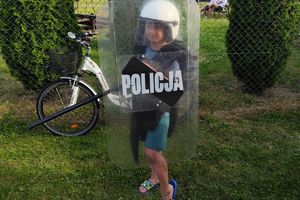 dziecko z tarczą w policyjnym kasku