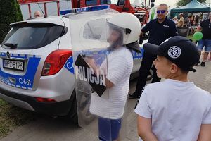 chłopiec w policyjnym kasku trzymający tarczę