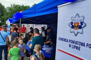 stoisko promocyjne Komendy Powiatowej Policji w Lipnie - policjanci rozmawiają z uczestnikami pikniku
