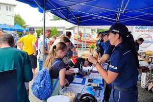 stoisko promocyjne Komendy Powiatowej Policji w Lipnie - policjanci rozmawiają z uczestnikami pikniku