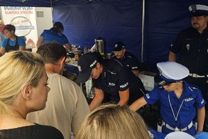 stoisko promocyjne Komendy Powiatowej Policji w Lipnie - policjanci rozmawiają z uczestnikami pikniku
