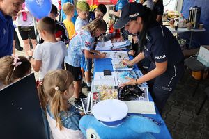 stoisko promocyjne Komendy Powiatowej Policji w Lipnie - policjanci rozmawiają z uczestnikami pikniku