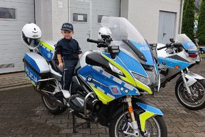 chłopiec w stroju policjanta na policyjnym motocyklu