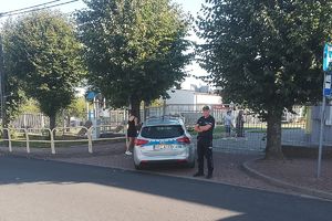 policjant obok radiowozu przy szkole