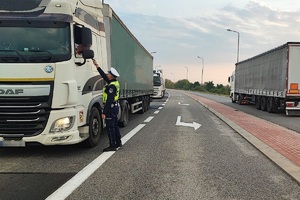 policjant kontroluje trzeźwość kierującego pojazdem ciężarowym