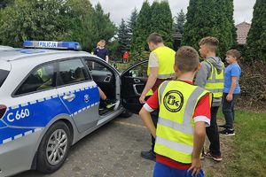 chłopcy oglądają policyjny radiowóz
