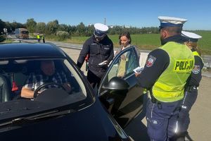 Policjanci i przedstawicielka PZU rozmawiają z kierowcami i wręczają materiały edukacyjne kampanii Mistrzu zwolnij