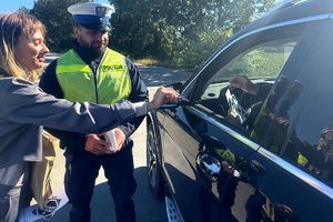 Policjanci i przedstawicielka PZU rozmawiają z kierowcami i wręczają materiały edukacyjne kampanii Mistrzu zwolnij