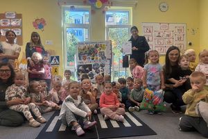 wspólne zdjęcie dzieci i ich opiekunek z policjantką